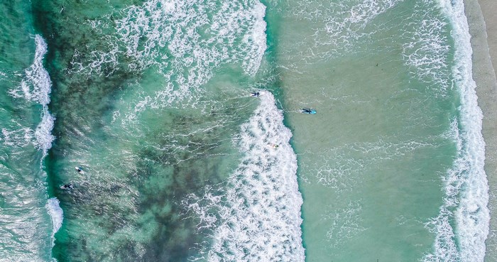 Surfers in Vazon Bay, Guernsey