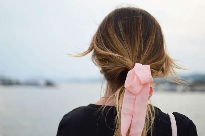 Woman with pink bow in her hair by the sea