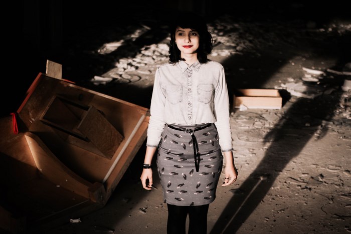 Woman in patterned skirt in abandoned building