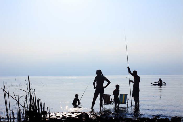 Family fishing and kayaking on the Sea of Galilee