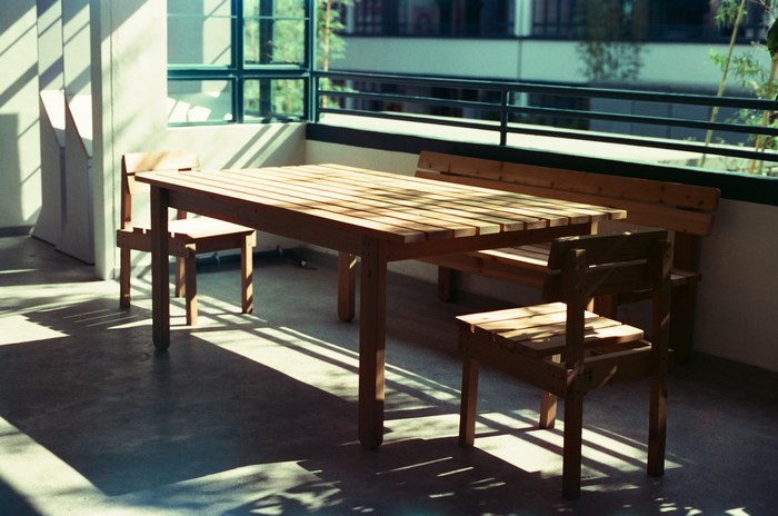 Wooden table and chairs on a sunlit balcony