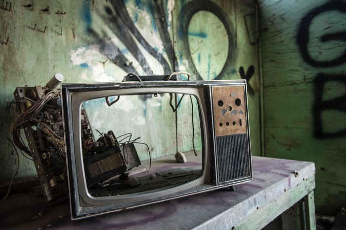 Abandoned television with graffiti in a derelict building