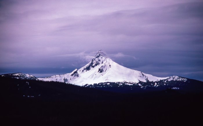 Snowcapped mountain peak under a purple sky
