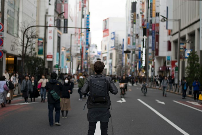 Person with backpack in a busy Japanese city street