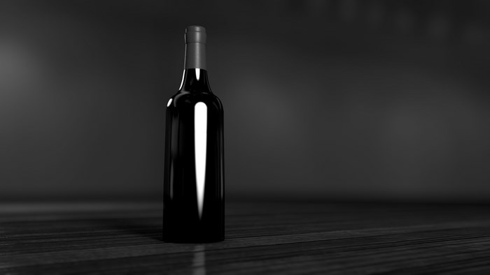 Black wine bottle on a dark wooden surface