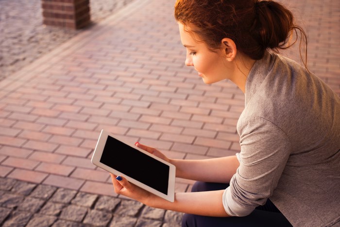 Young woman with red hair using a tablet