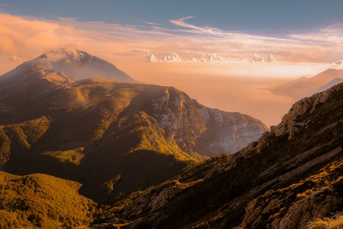 Mountain landscape at sunset with clouds and trees