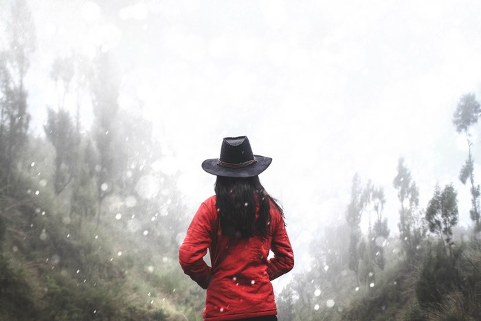 Woman in red coat and hat in snowy forest