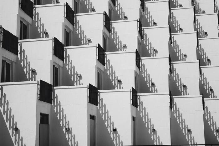 Geometric pattern of white balconies with black railings and shadows