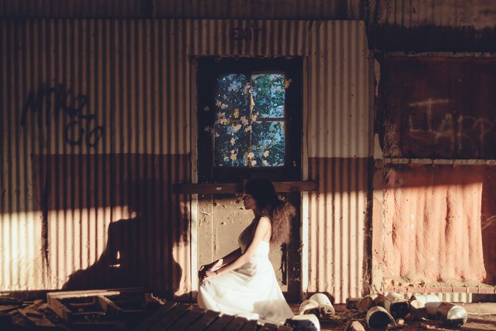 Woman in white dress in abandoned room with graffiti