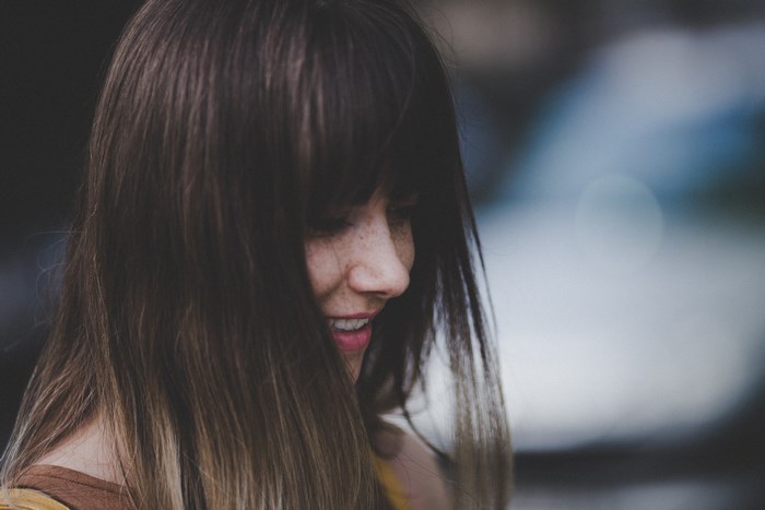 Woman with freckles smiling outdoors