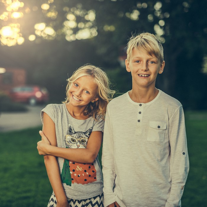 Brother and sister smiling in sunlight