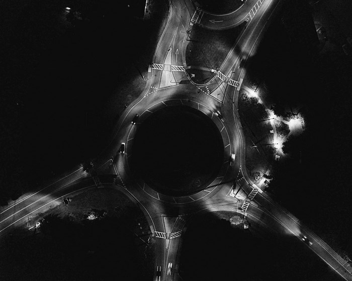 Aerial view of a nighttime roundabout with cars