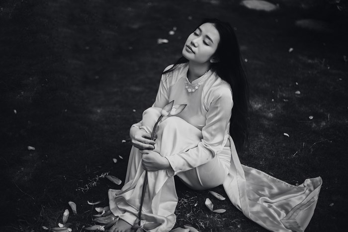 Woman in traditional Vietnamese Ao Dai holding a lotus flower