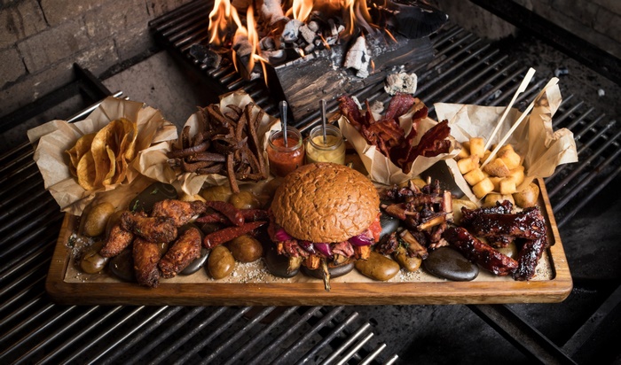 Barbecue platter with burger, ribs, wings, and fries