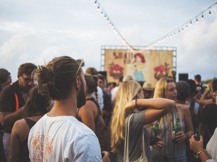 People at an outdoor festival with a stage and lights