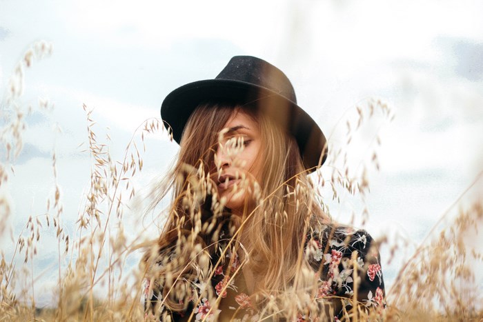 Woman in a floral shirt and hat in a wheat field