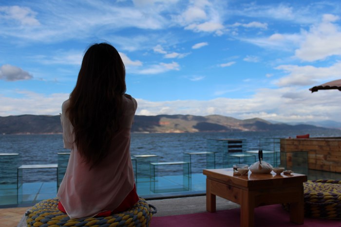 Girl sitting by the lake in Dali, China