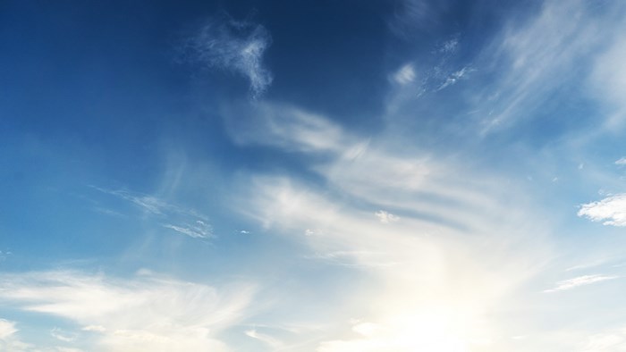 Blue sky with wispy clouds and bright sun