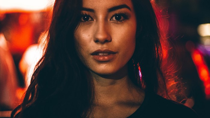 Woman with red lighting in an urban setting