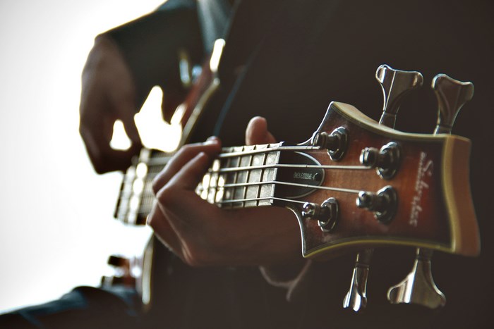 Close-up of a person playing a bass guitar