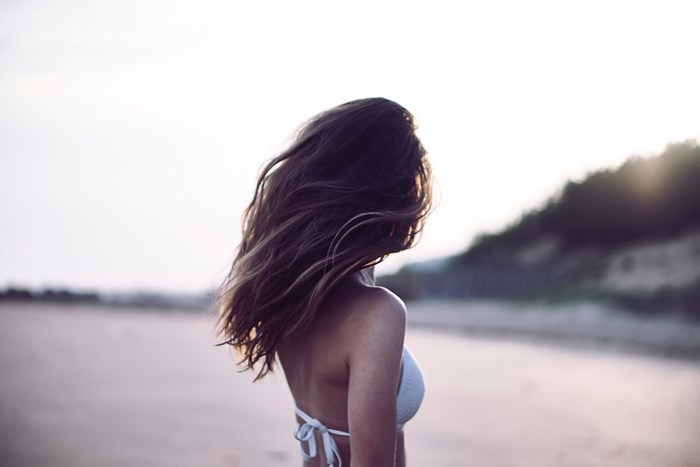Cheerful Woman with Flowing Hair on Beach Sunset