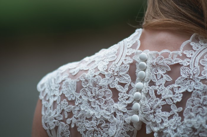 Close-up of a white lace wedding dress with buttons
