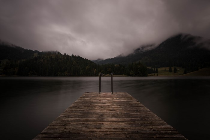 Moody Wooden Jetty Extending into Cloudy Lake