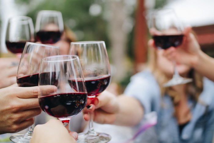 People toasting with red wine glasses