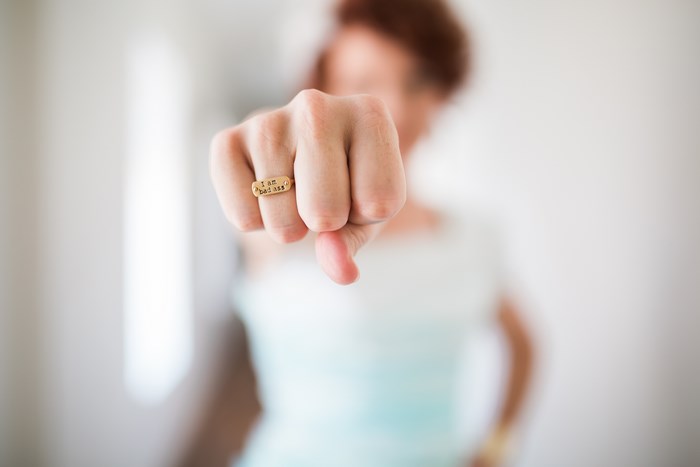 Woman with "I am badass" ring gives thumbs down