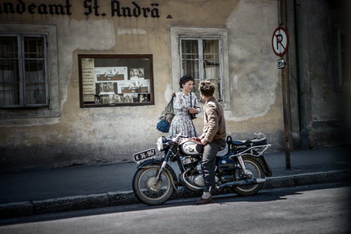 Man and woman talking by a motorcycle
