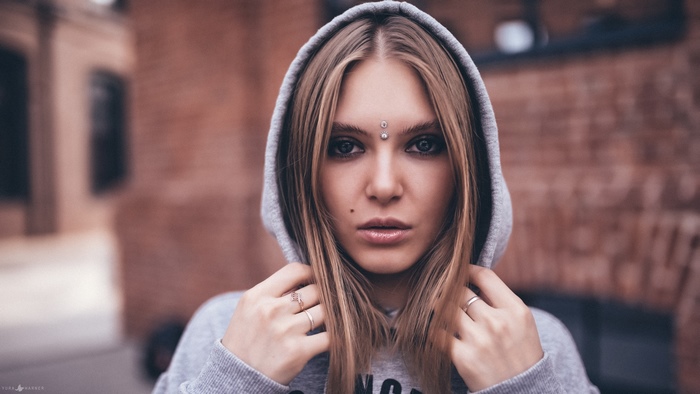 Blonde girl with piercings in a hoodie