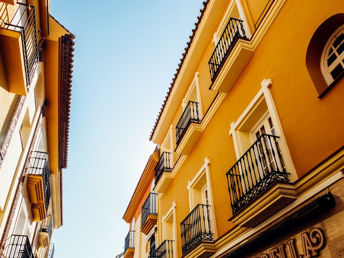 Yellow buildings with balconies under a blue sky