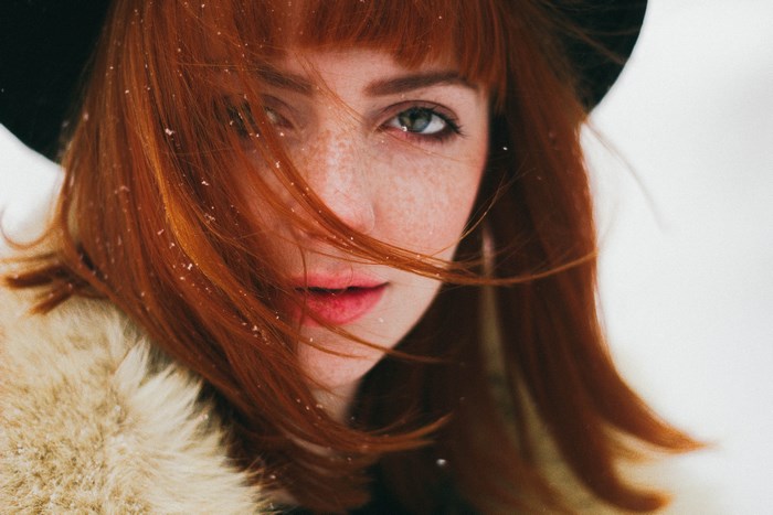 Woman with red hair and freckles in the snow