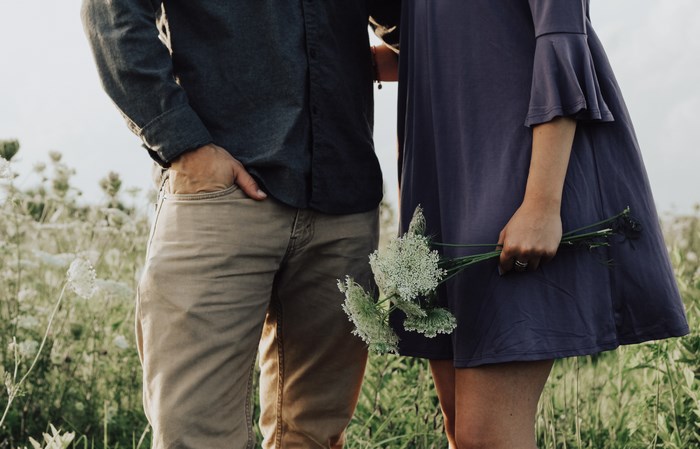 Couple holding flowers in a field