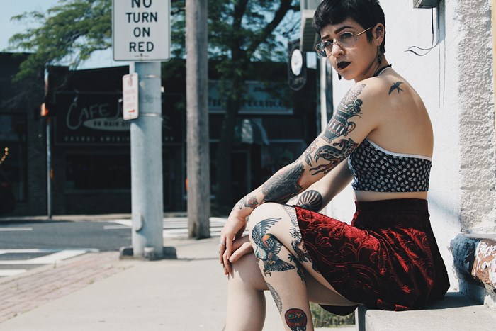 Woman with tattoos sitting on steps