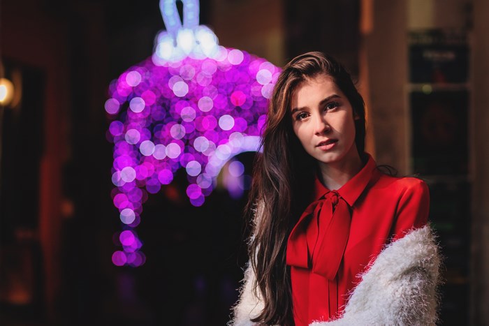 Woman in red shirt with fur jacket and bokeh lights