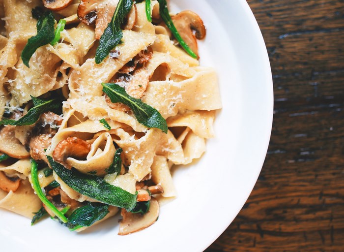 Pasta with mushrooms, sage, and cheese in a white bowl