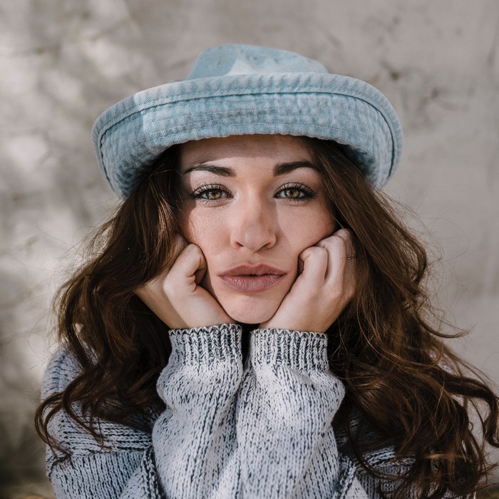 Woman wearing a blue hat and grey sweater