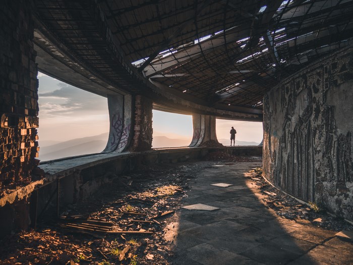 Buzludzha Monument interior with a person overlooking mountains