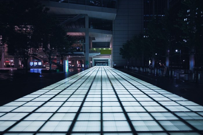 Illuminated walkway in a modern city at night