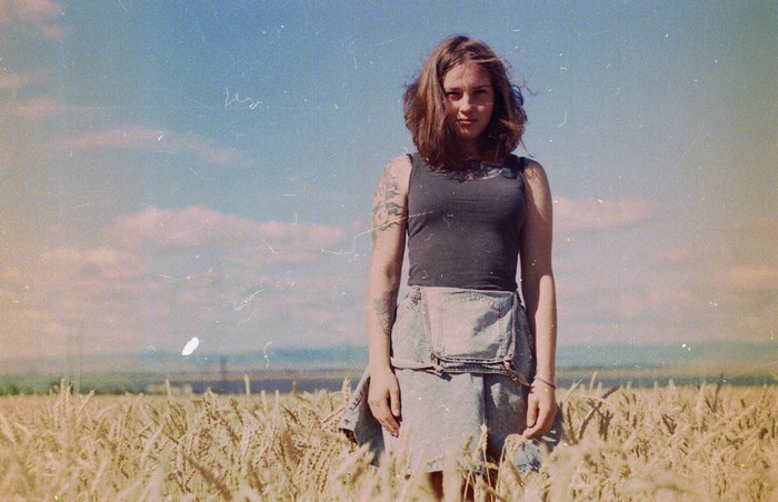 Woman with tattoos in a wheat field