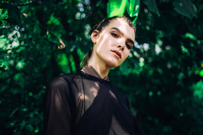 Fashion portrait of a female model in greenery