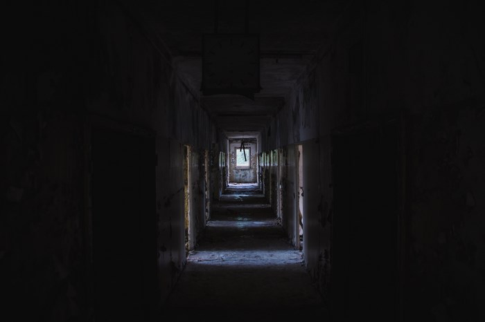 Abandoned building corridor with light at the end