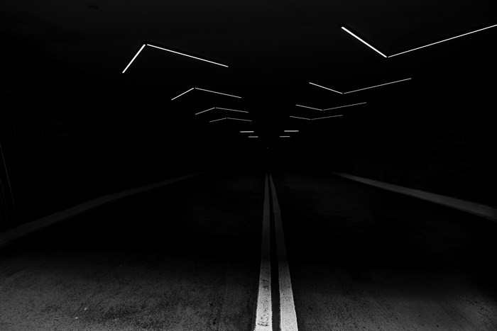 Dark tunnel with linear lights and road markings