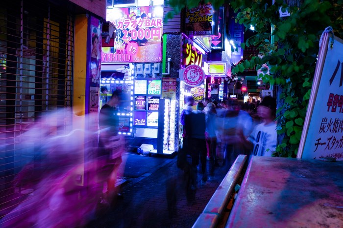 Night street with neon signs and people