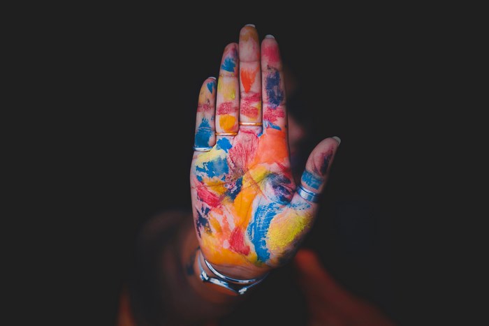 Colorful hand with paint and rings