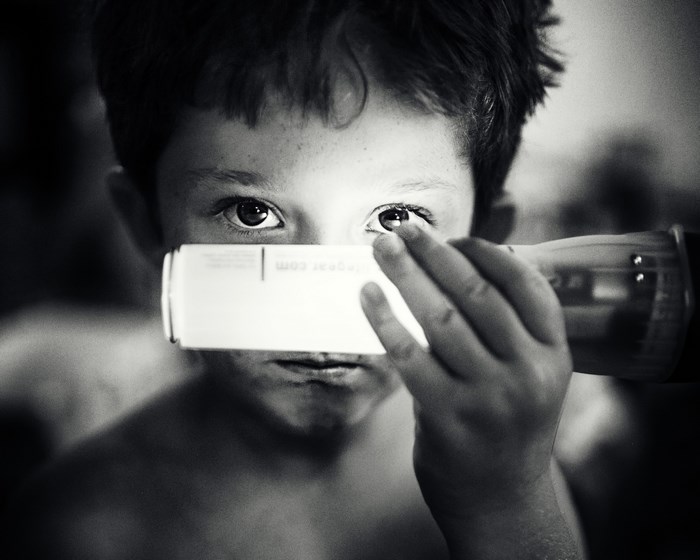 Boy holding a glow stick to his eye