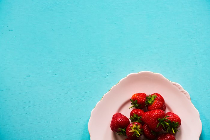 Fresh Strawberries on Pink Plate with Blue Background