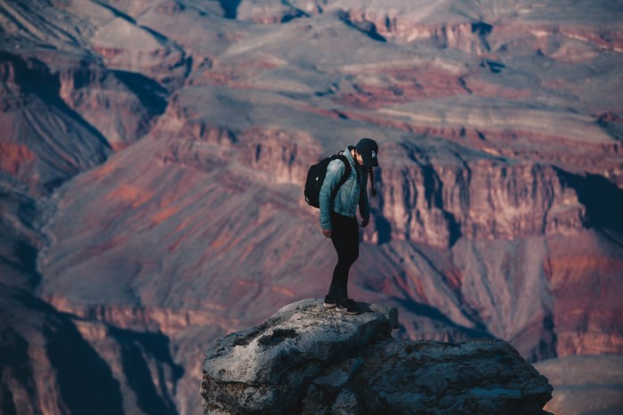 Man with backpack on Grand Canyon ledge
